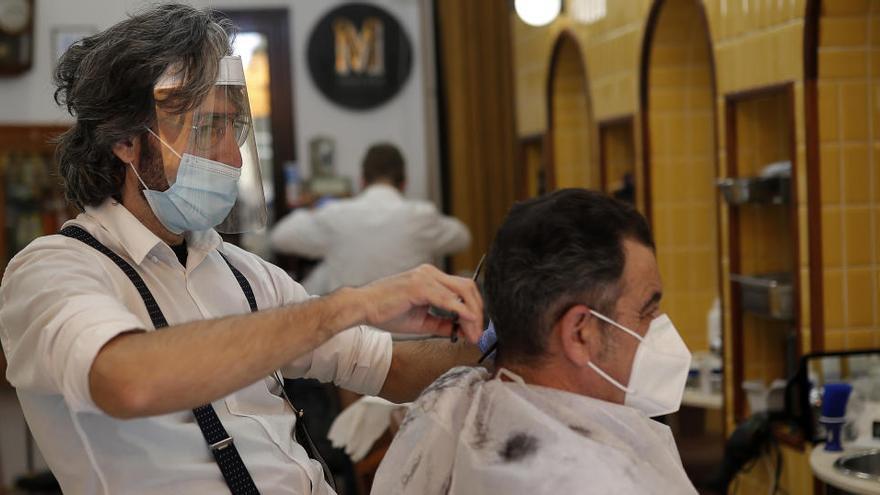 Un peluquero en su empresa en Madrid.