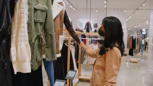 Una mujer observa una prensa de la tienda Amazon Styles