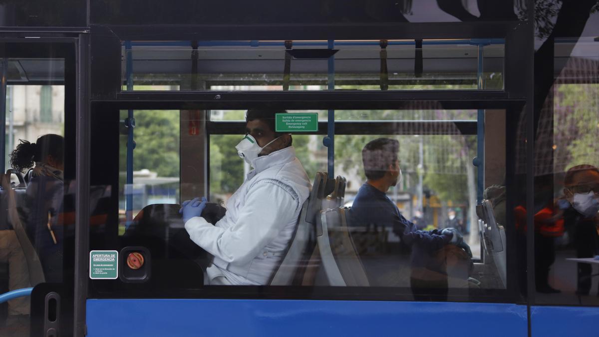 Viajeros con mascarilla en un autobús de Madrid.