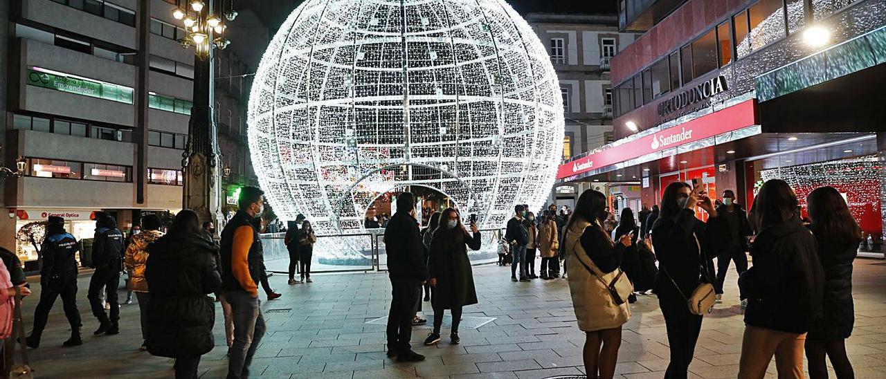 Vigueses, haciéndose fotos delante de la bola de Navidad. |   // RICARDO GROBAS