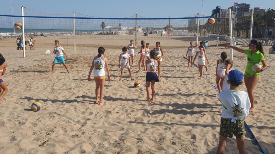 Un grupo de alumnos de la base del club trabaja con una monitora en una de las 22 canchas de vóley playa coordinadas por el CVP Costa Blanca en San Juan.