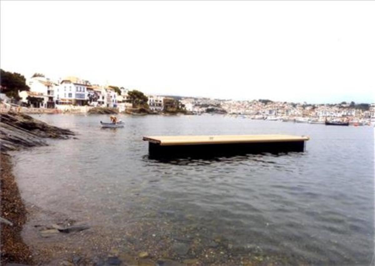 Embarcadors allunyats de la platja.Durant els mesos d’estiu, en diverses platges de Cadaqués s’instal·len uns embarcadors provisionals per poder accedir a les embarcacions des de la sorra. Però a causa de la distància a què estan col·locats, tal com mostra la fotografia feta al Llane Petit, la seva utilitat és més que dubtosa, ja que el difícil és no mullar-se quan intentes pujar a l’embarcador.