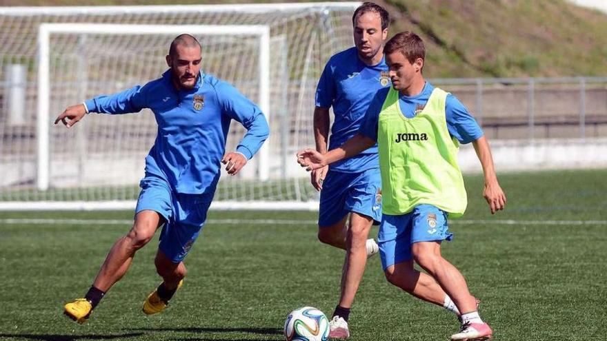 Benja se lleva el balón ante la presencia de Pedro García y Jacobo en un entrenamiento.
