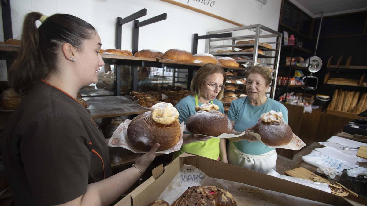 Tres mujeres muestran algunas de las monas que elaboran estos días.