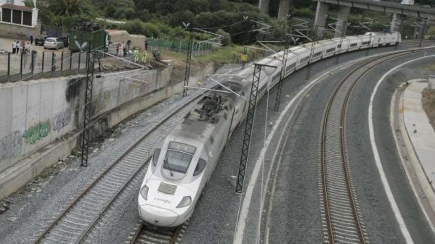 Un tren pasa por la vía en la que descarriló un Alvia 730 el pasado día 24, a su paso por Angrois.  // Xoán Álvarez