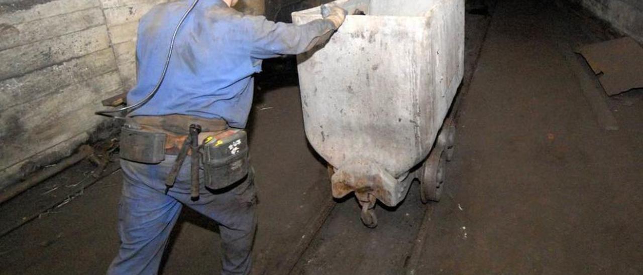 Un minero arrastra una vagoneta en una explotación de la comarca del Caudal.
