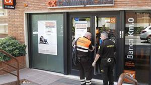 Dos vigilantes cierran en el momento de cerrar la sucursal de CatalunyaCaixa de la calle de Ganduxer donde murió la subdirectora.