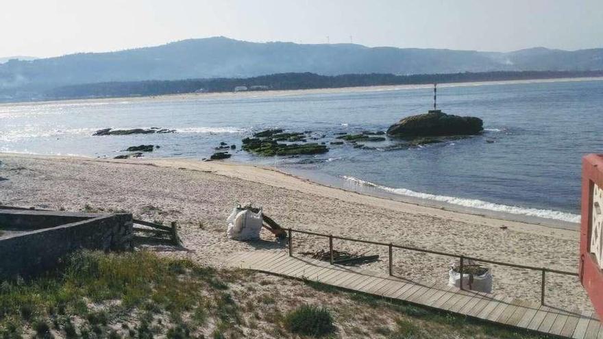 La playa de O Muíño de Camposancos, con sacos donde se depositan residuos retirados a mano.  // E. G.