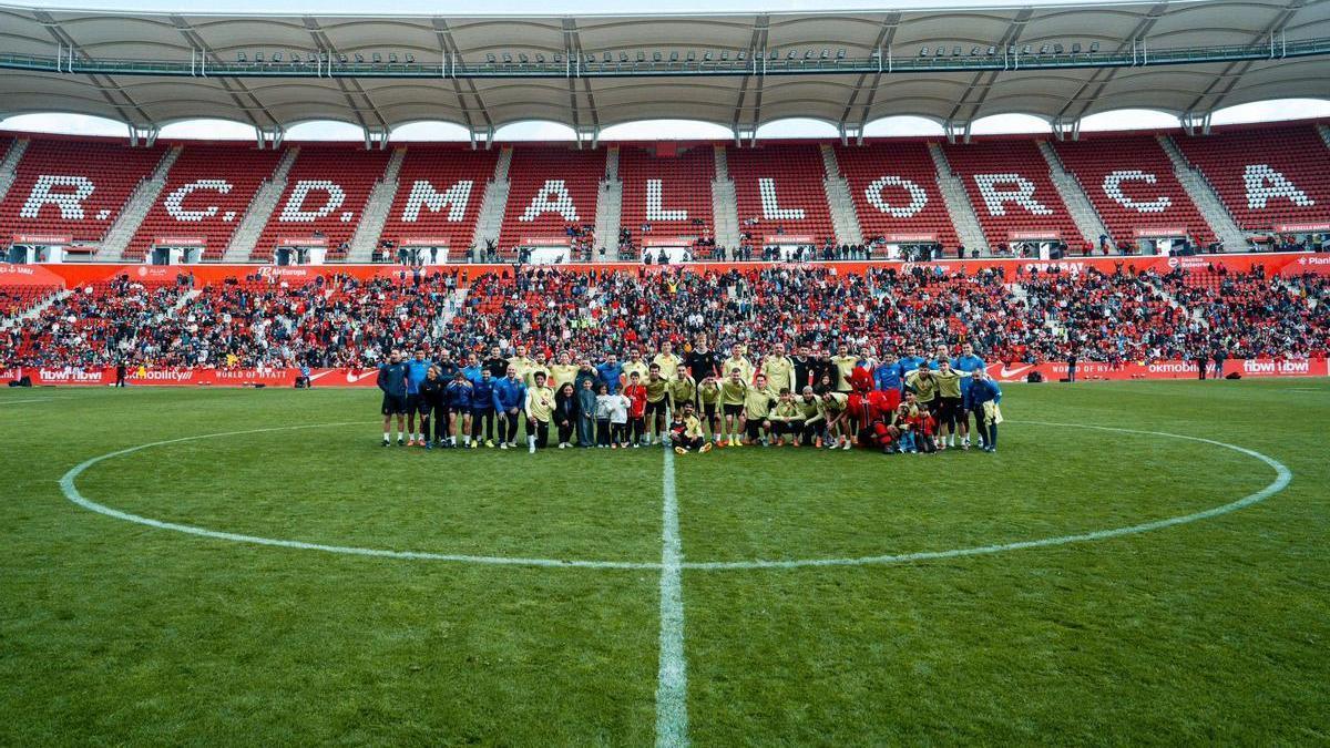 Foto de familia de la plantilla del Mallorca junto a aficionados.