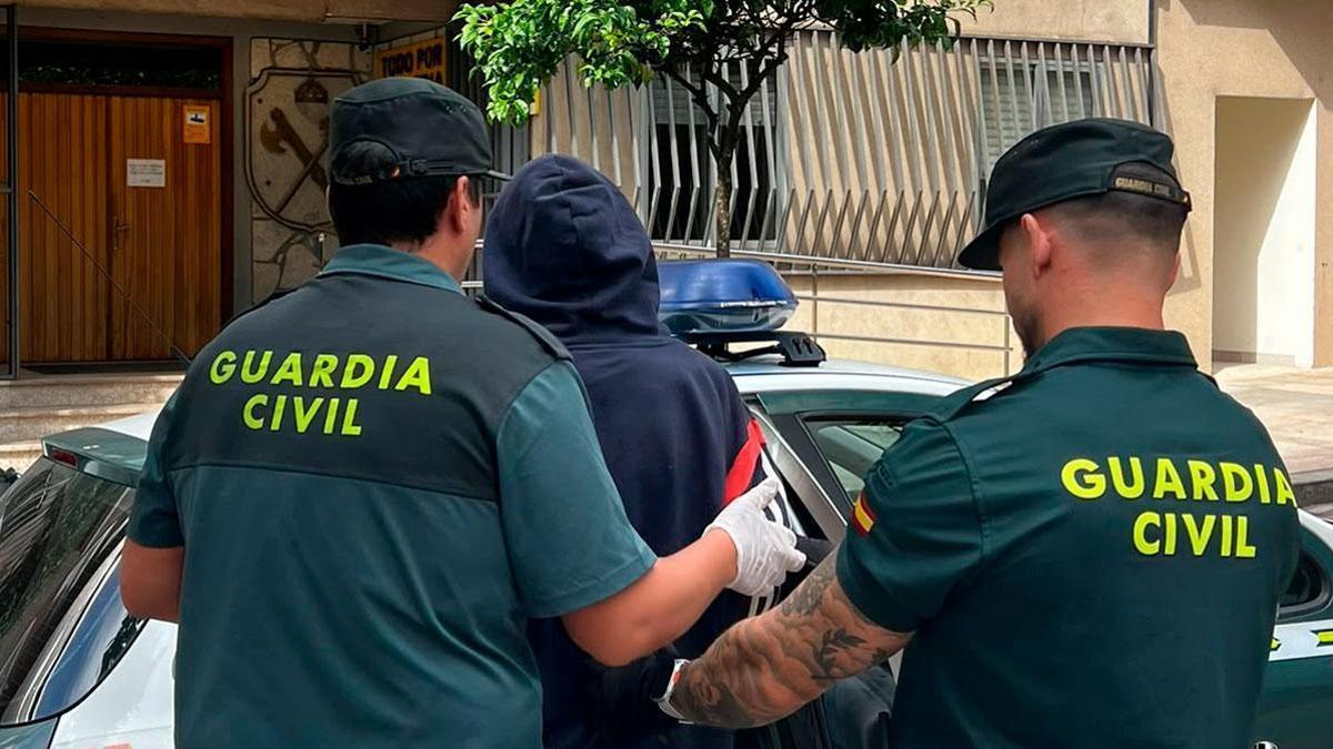 Dos agentes de la Guardia Civil acompañan al detenido, con la capucha.