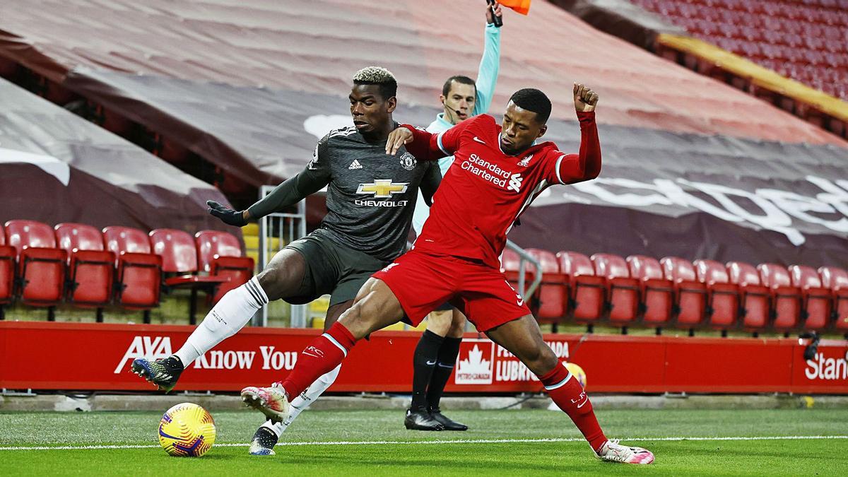 Paul Pogba disputa un balón al jugador del Liverpool Georginio Wijnaldum durante el derbi inglés disputado ayer en Anfield. |  // REUTERS