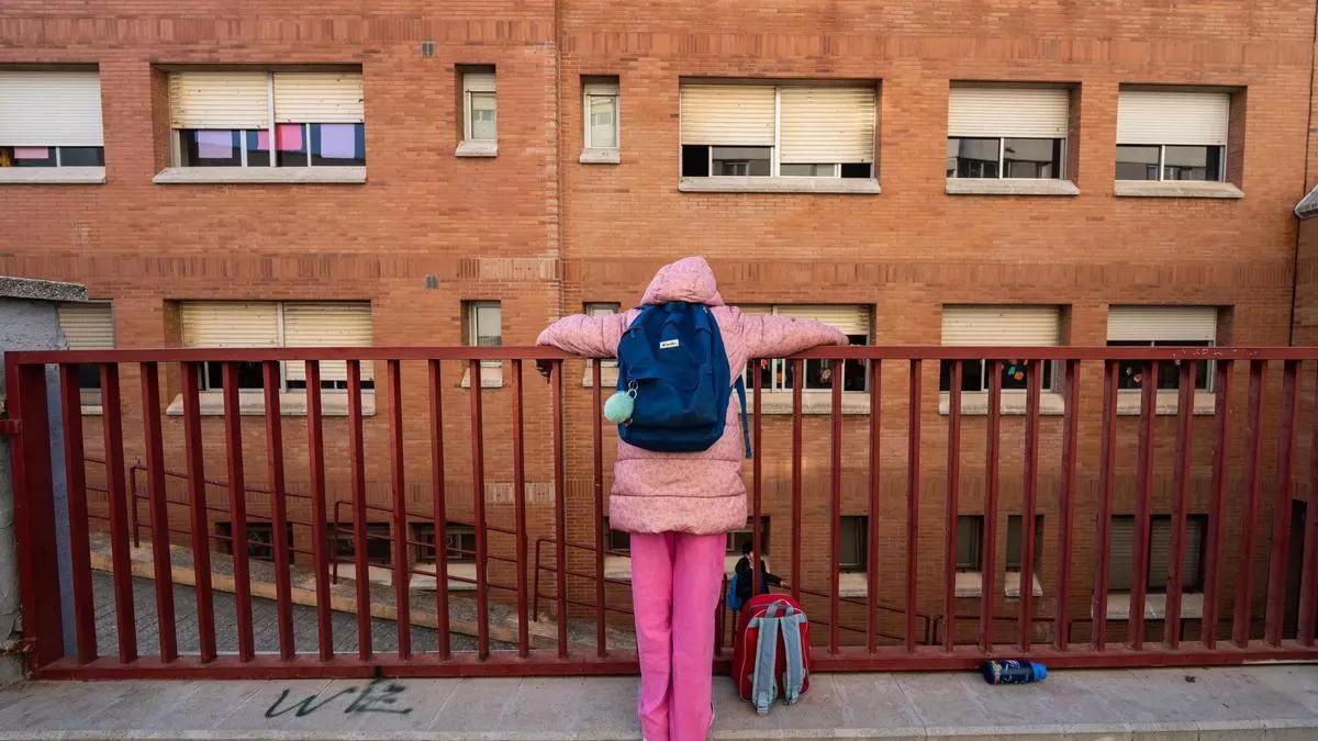Una niña en la entrada de su colegio.