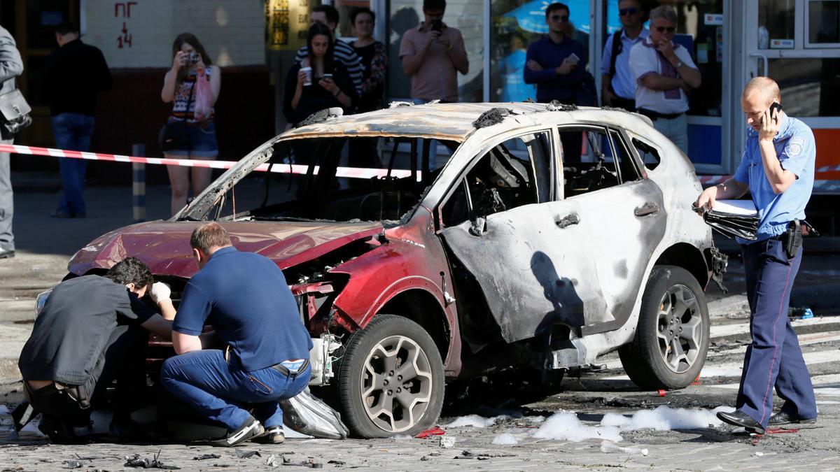 Agentes inspeccionan el coche en el que viajaba el periodista Pavel Sheremet, este miércoles en Kiev.