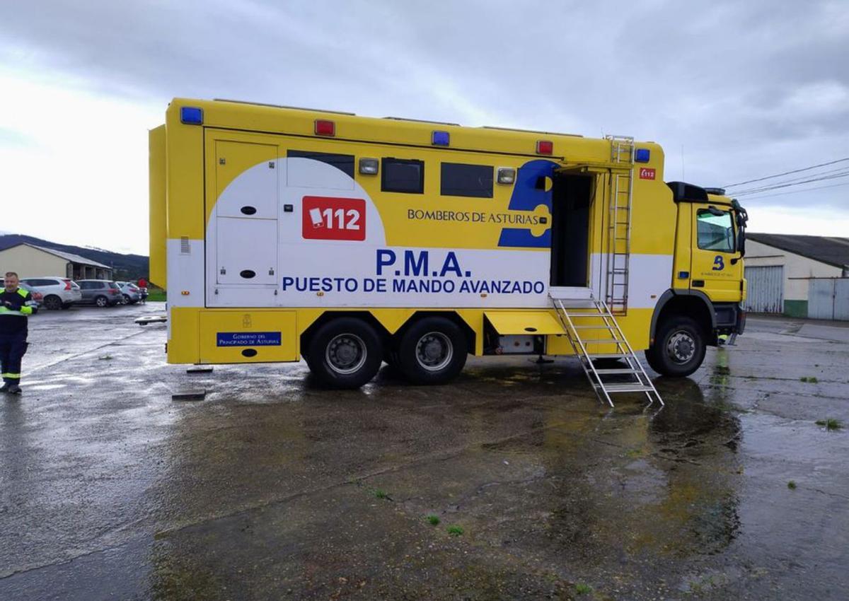 Un guardia civil observa la costa coañesa, con el helicóptero al fondo.