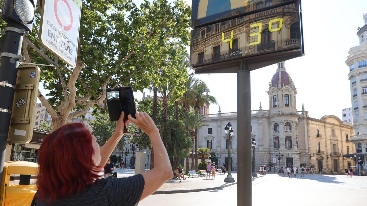 Una mujer fotografía un termómetro en el centro de València, este miércoles.