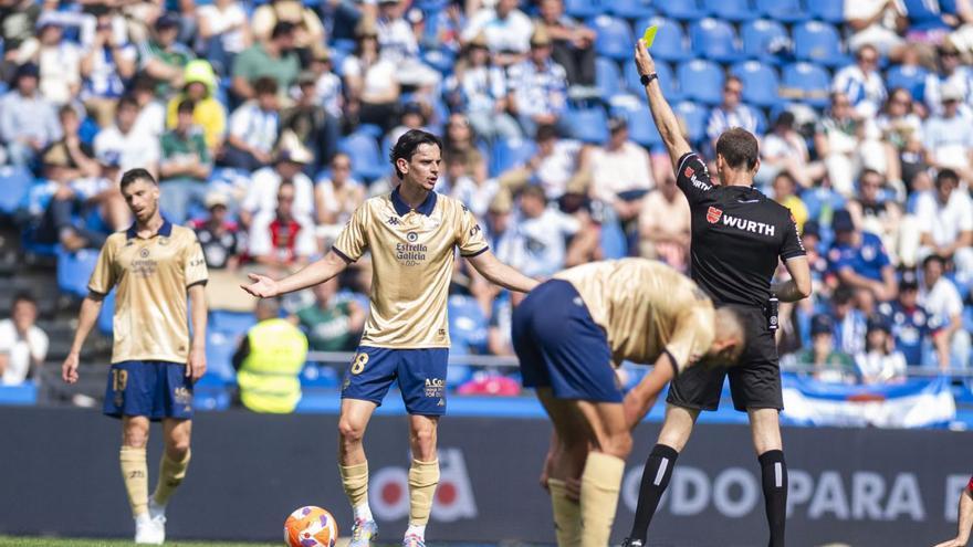 El árbitro amonesta a Charlie Patiño en el partido contra el Granada en Riazor.