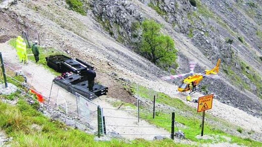 El helicóptero deposita materiales en la zona del argayo de la senda del Cares.