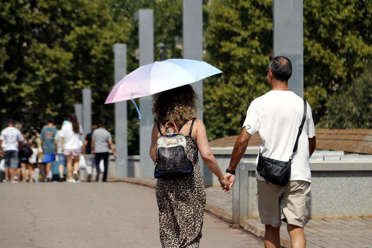 Una dona camina amb un paraigua en un dia calurós