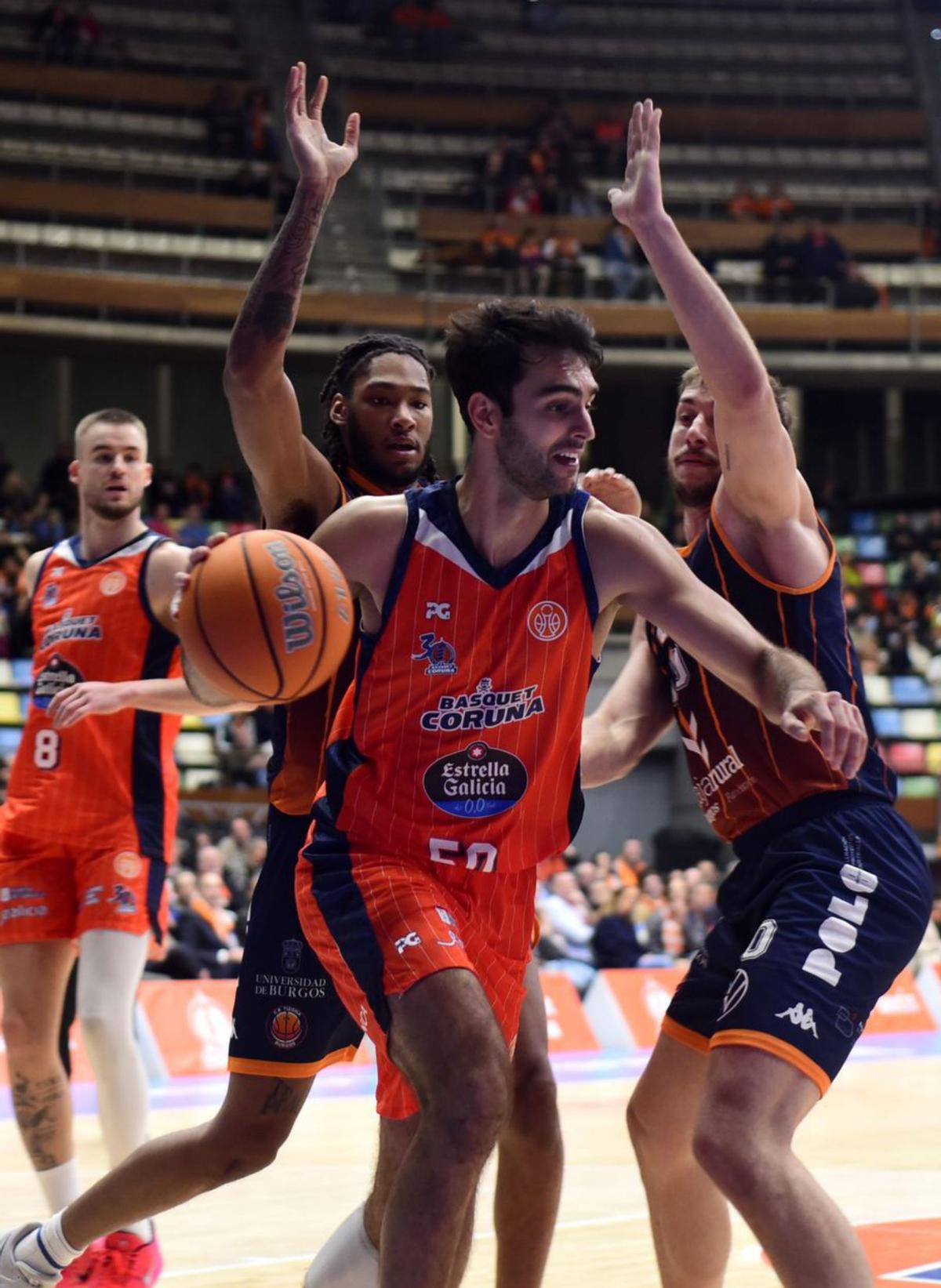 Jacobo Díaz se lleva la pelota ante dos oponentes. |  Casteleiro