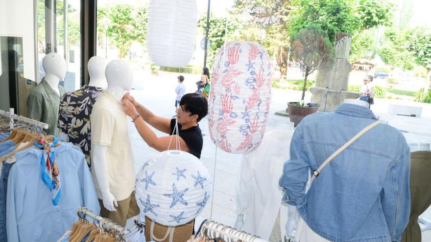 Arreglo de un escaparate, ayer, en
 un comercio en Cangas. |  G. Núñez