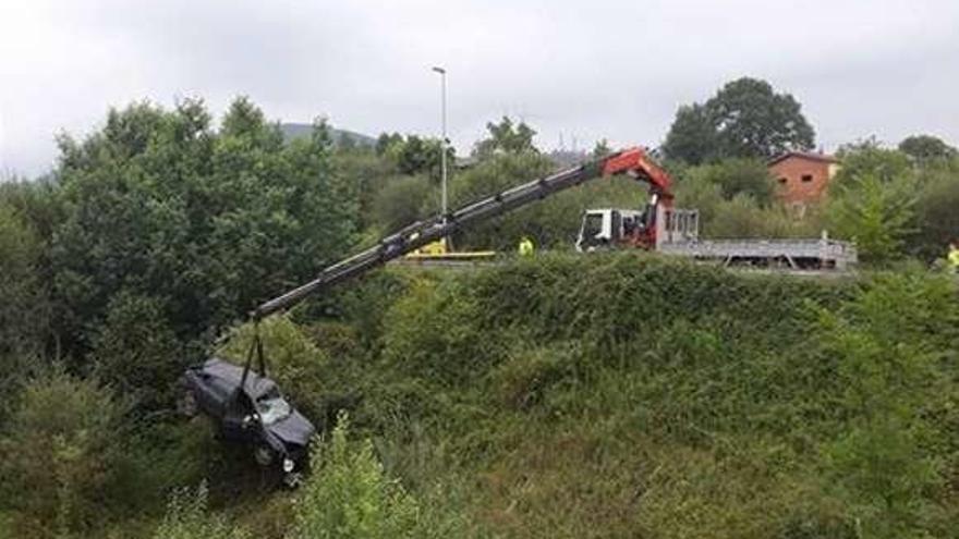 La grúa retira el vehículo en el que fue encontrado el cuerpo, en la A-63.