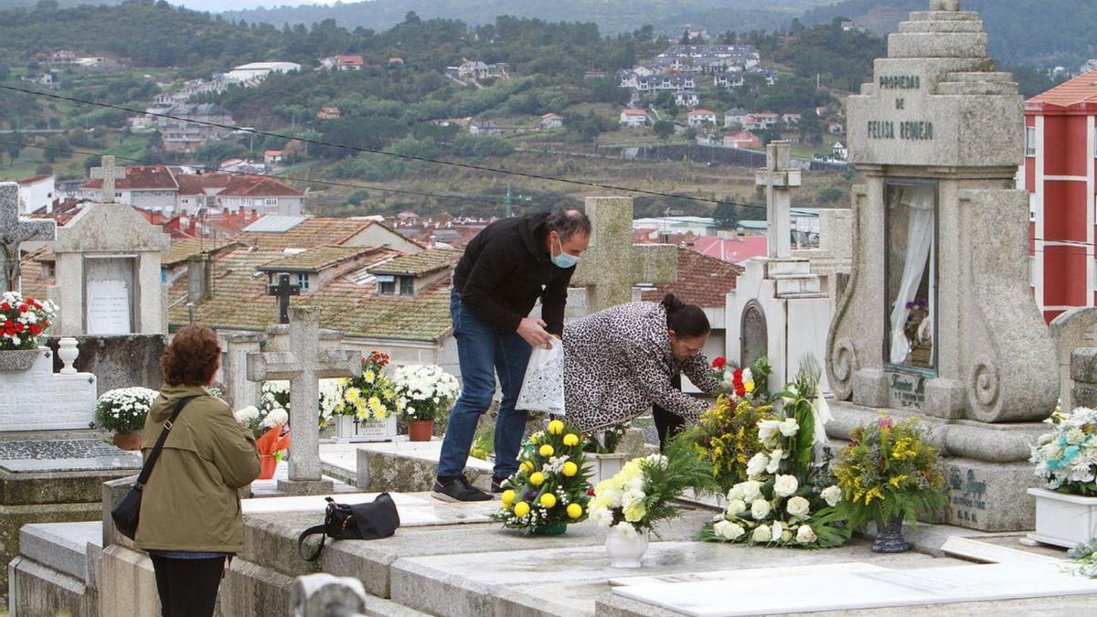 Una pareja deposita unas flores sobre la tumba de un ser querido. |   // IÑAKI OSORIO