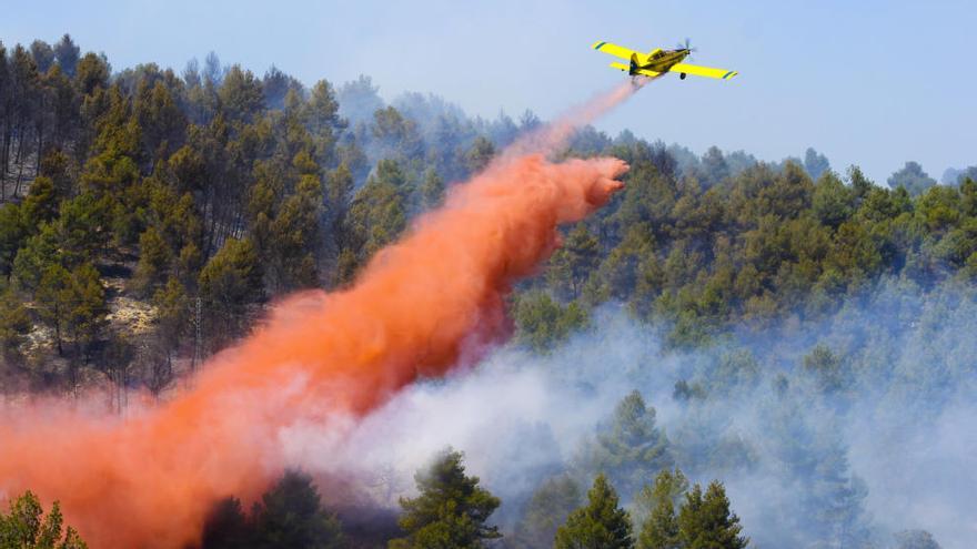 Una avioneta descargando en la zona del incendio.