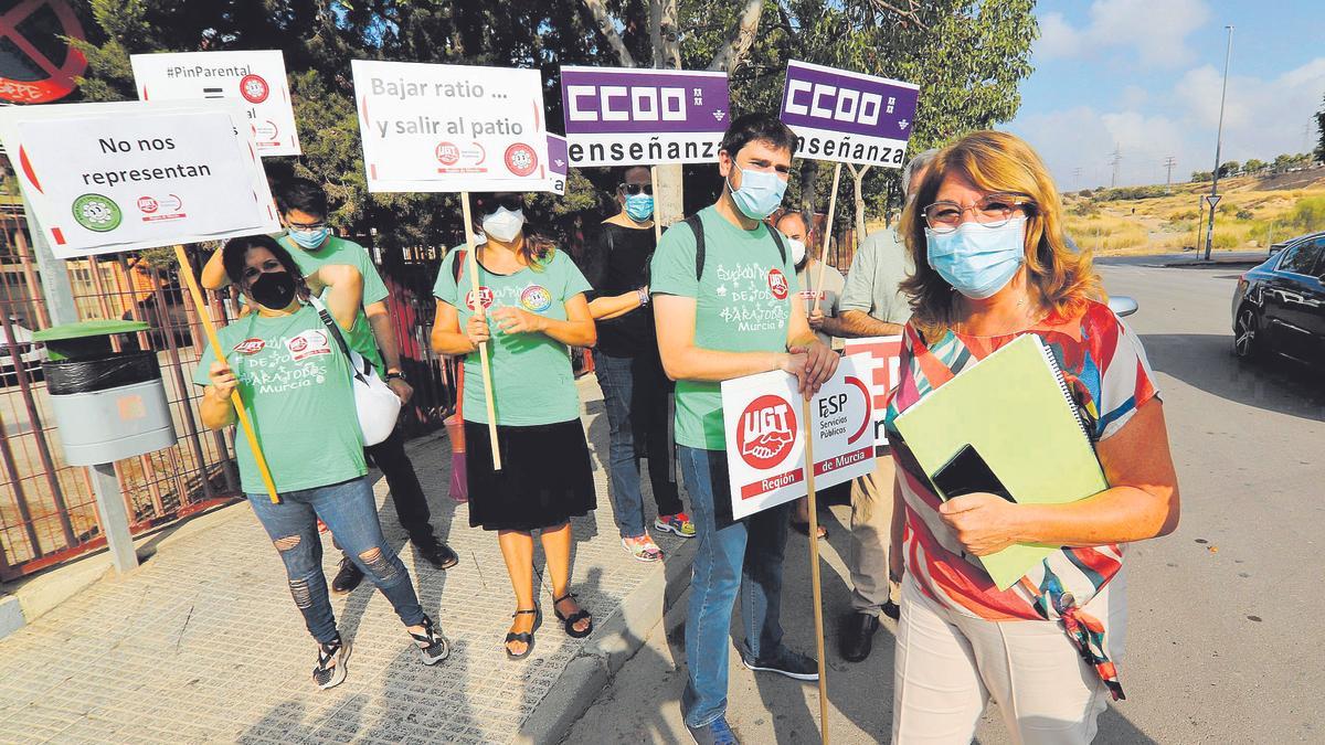 Mabel Campuzano y  detrás la protesta de   los sindicatos.