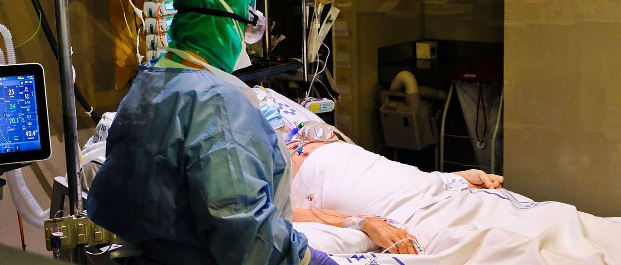 Un profesional sanitario atiende a un paciente en una planta Covid del Hospital de Gran Canaria Doctor Negrín.
