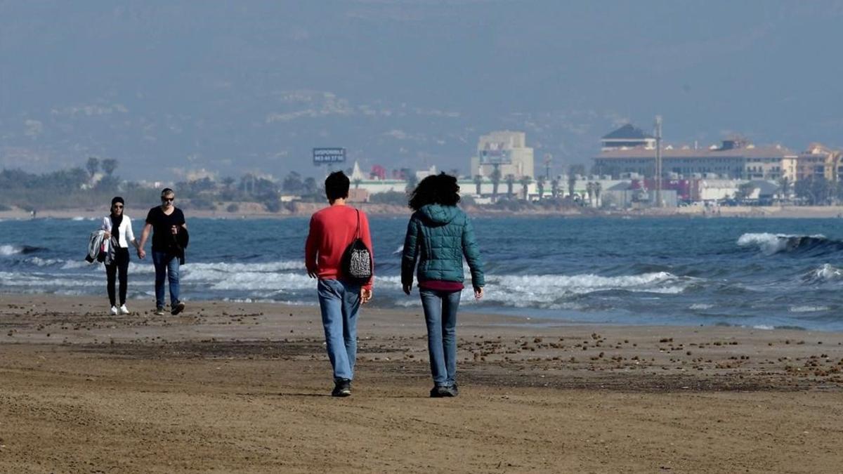 Personas paseando por la playa de Valencia este sábado.
