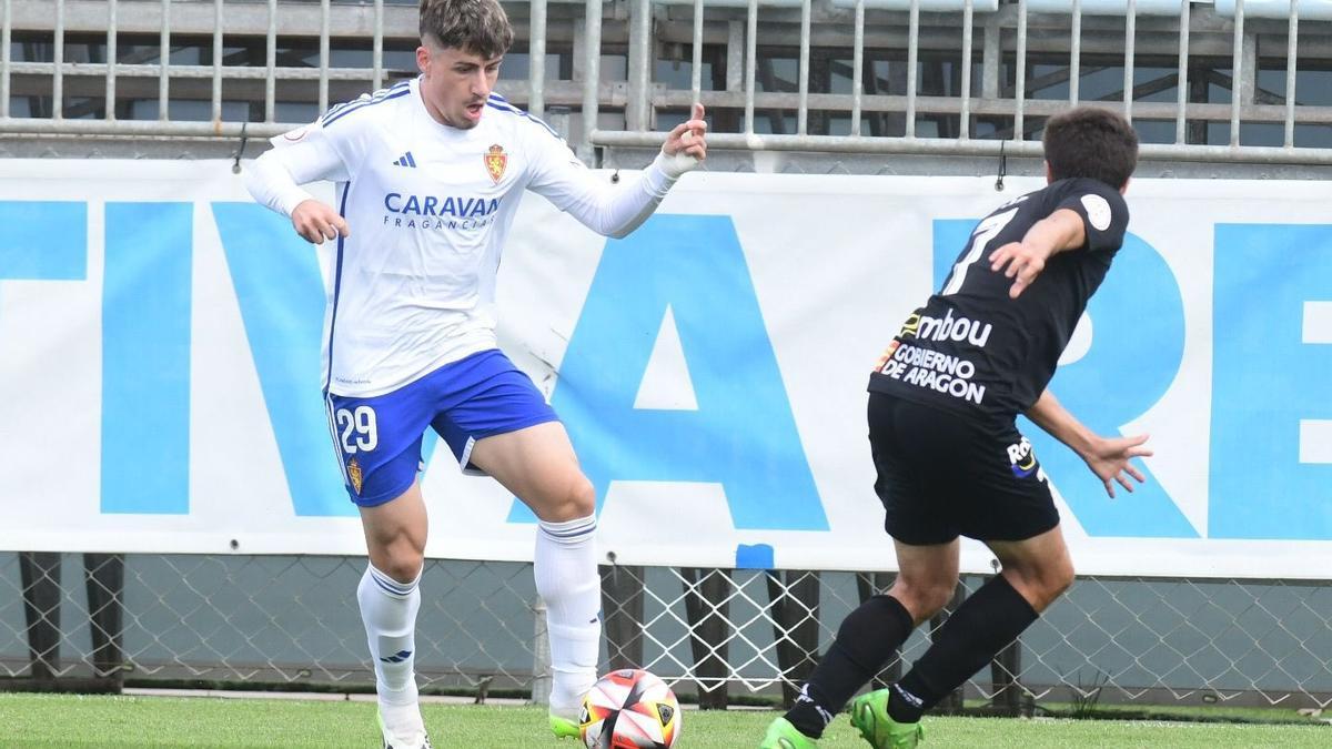 Adrián Liso trata de encarar a Val en el encuentro entre el Deportivo Aragón y el Barbastro.