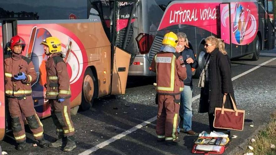 Bomberos y viajeros en el lugar del accidente; detrás los dos autocares sinistrados. // Carles Colomer