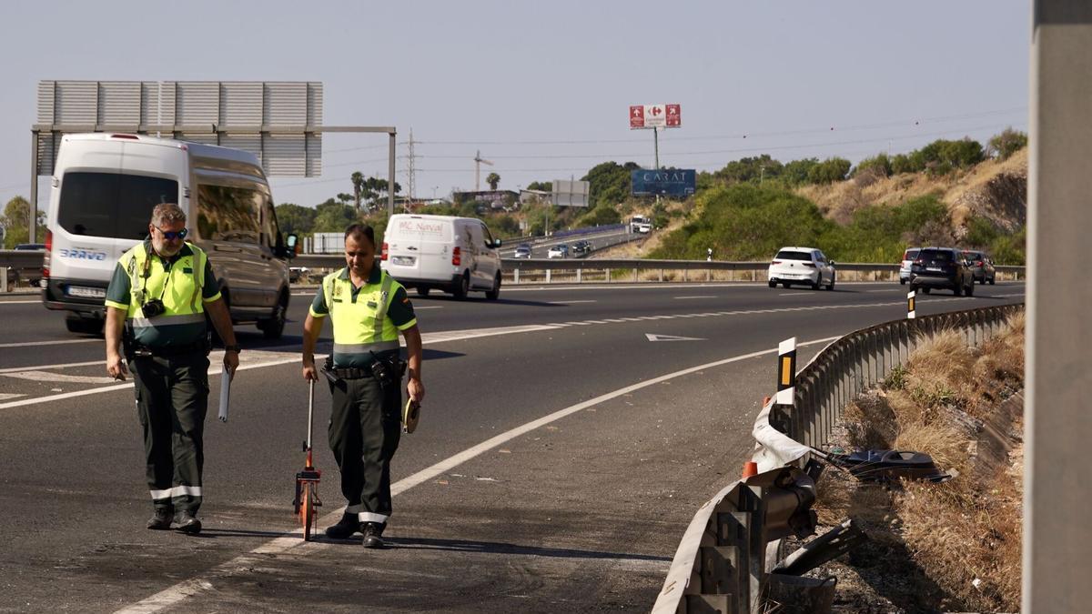 Imagen de archivo que muestra a dos guardias civiles de tráfico, durante la investigación de otro accidente de tráfico mortal en la A-7.