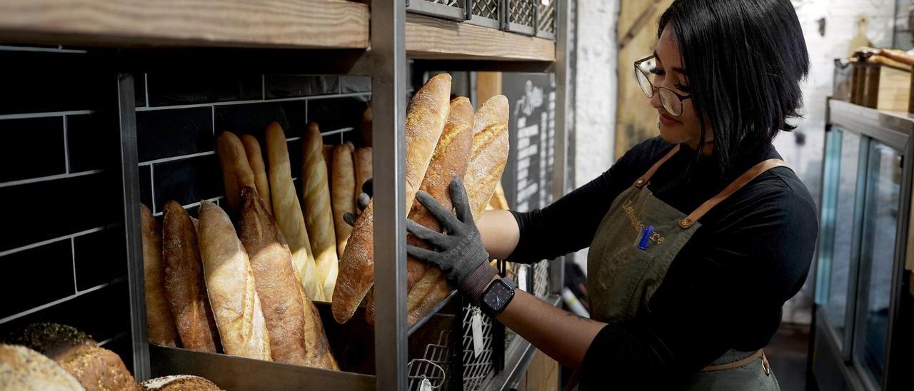 Una empleada de una panadería, durante el desempeño de su trabajo en el establecimiento, un tipo de negocio que encaja con el emprendimiento.