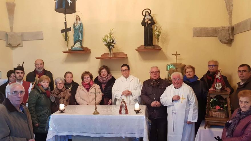 Agustín Hevia Ballina, a la derecha, junto al altar, en una pasada celebración, rodeado de vecinos de la parroquia de Poreñu. | V. A.