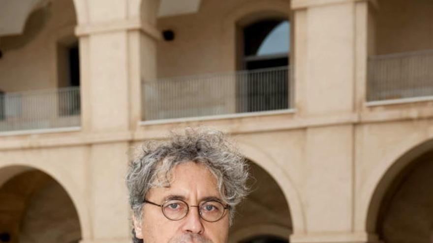 El escritor coruñés Manuel Rivas posa con su novela &quot;Todo es silencio&quot; en el patio interior de la UPCT