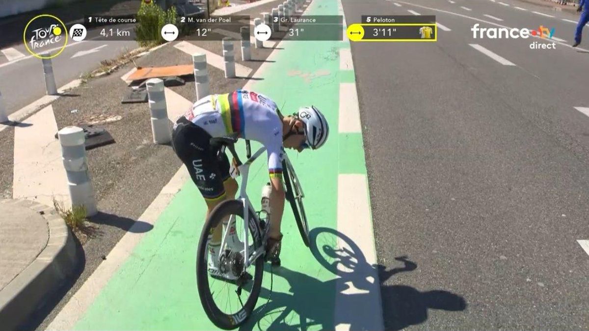 Pogacar repara la bici tras levantarse del suelo.