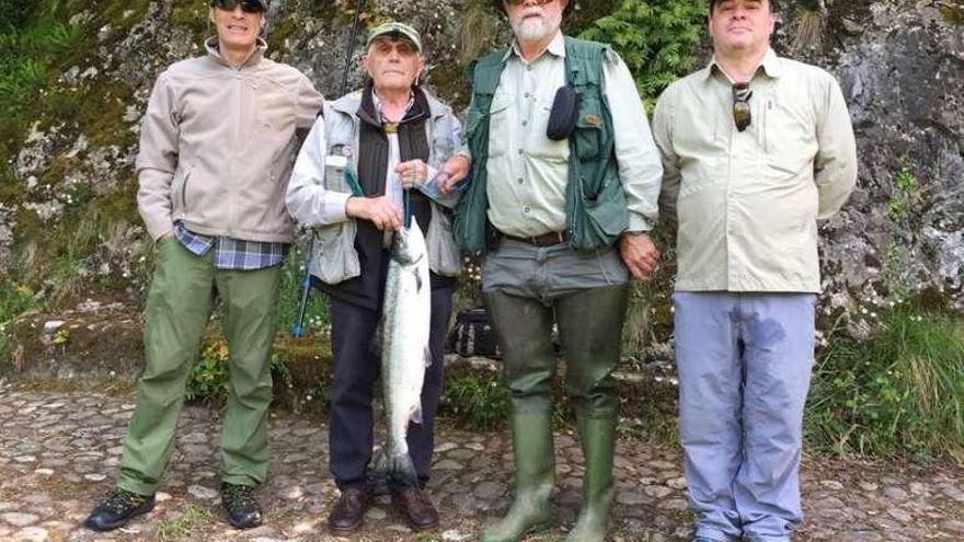 Por la izquierda, Pablo Collado, Julio Ampudia, Javier Collado y Jorge Collado, ayer, en Monejo, con el primero de los salmones capturados.