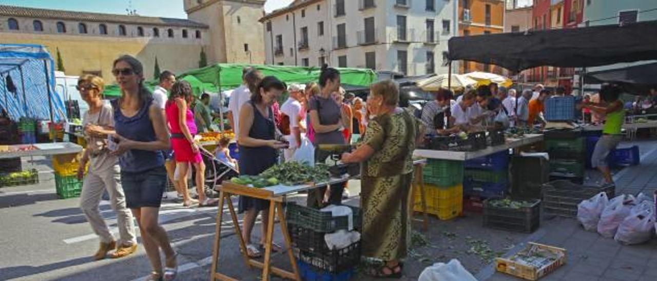 Dos visitantes compran en uno de los puestos del mercado de Cocentaina.