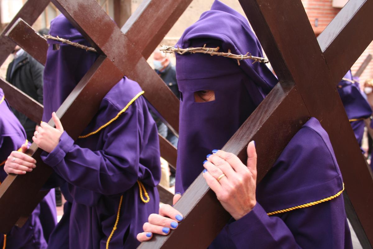 Penitentes con la cruz a cuesta camino del Calvario, custodiado por el Paso Morado.