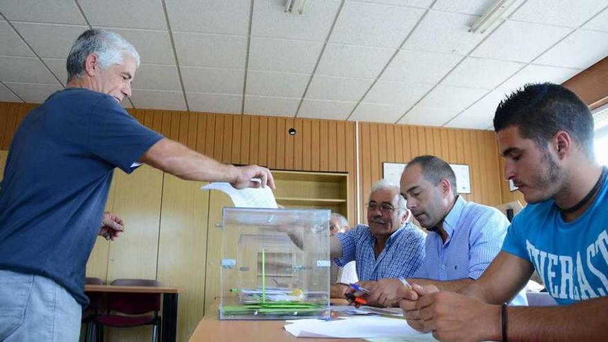 Un afiliado deposita su voto en la urna en las anteriores elecciones en la cofradía de Cangas. // G.Núñez