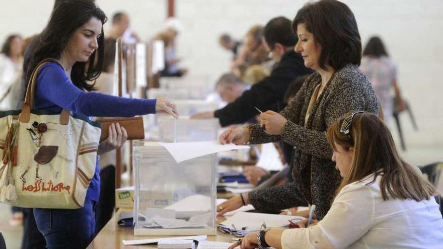 Una mujer vota en una mesa electoral en A Coruña.