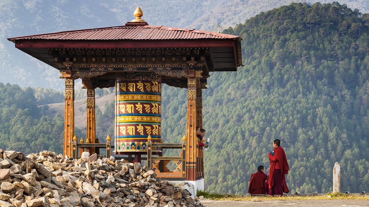 Las ruedas de oración y los monjes budistas forman parte del paisaje cotidiano en los caminos del Himalaya butanés.