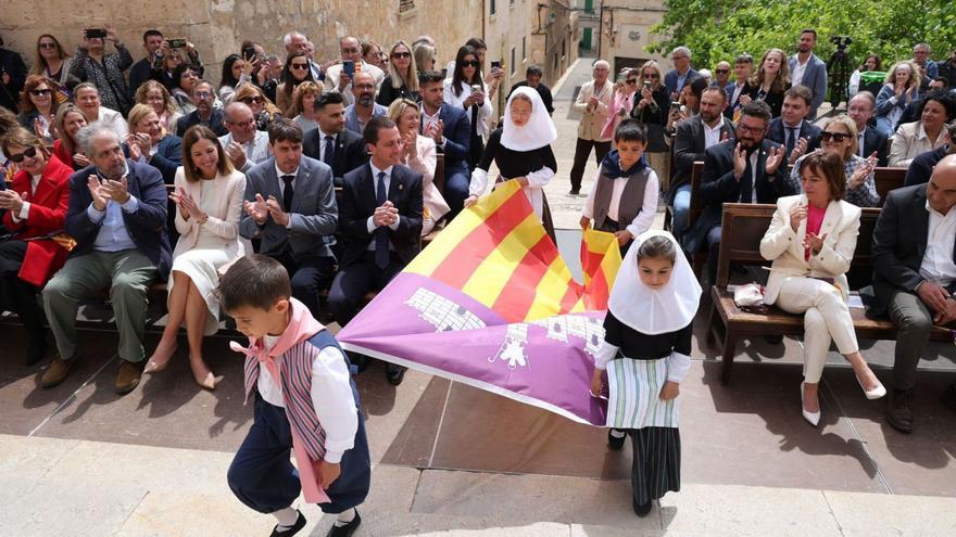 Cuatro niños vestidos de payeses portan la bandera de Mallorca, ayer, en Sineu. | CONSELL