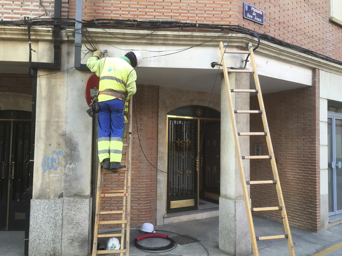 Un operario instala un cable en fachada en un edificio cercano a San Juan del Mercado en 2015.