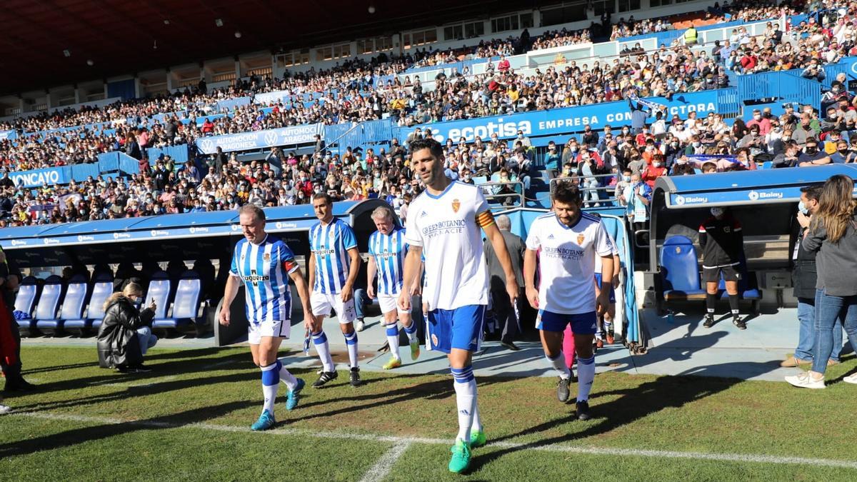 Los veteranos de Real Zaragoza y Real Sociedad saltando al césped en el encuentro benéfico.