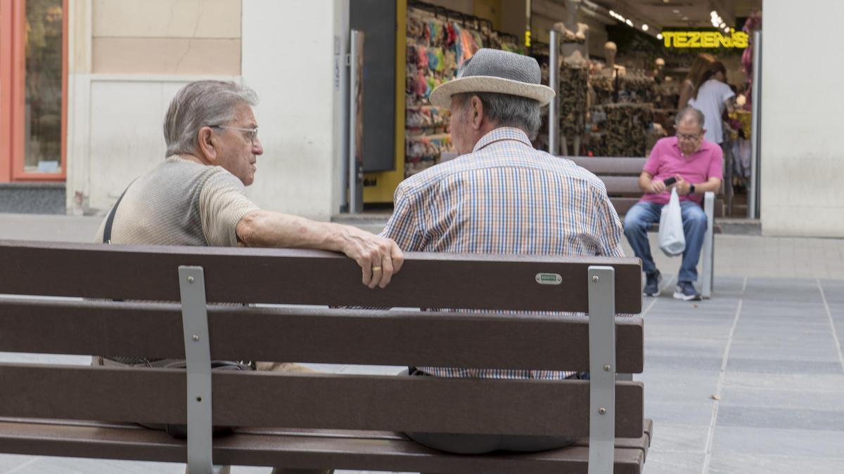 Uns jubilats descansen als bancs.