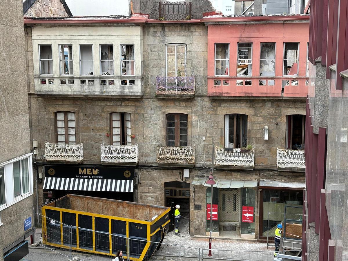 Un contenedor y trabajadores, ante el inmueble