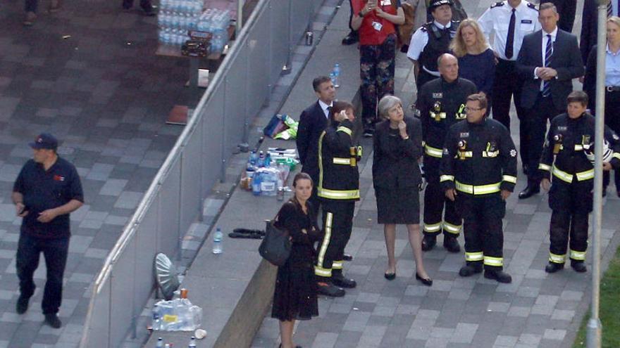 La primera ministra británica dialoga con bomberos.