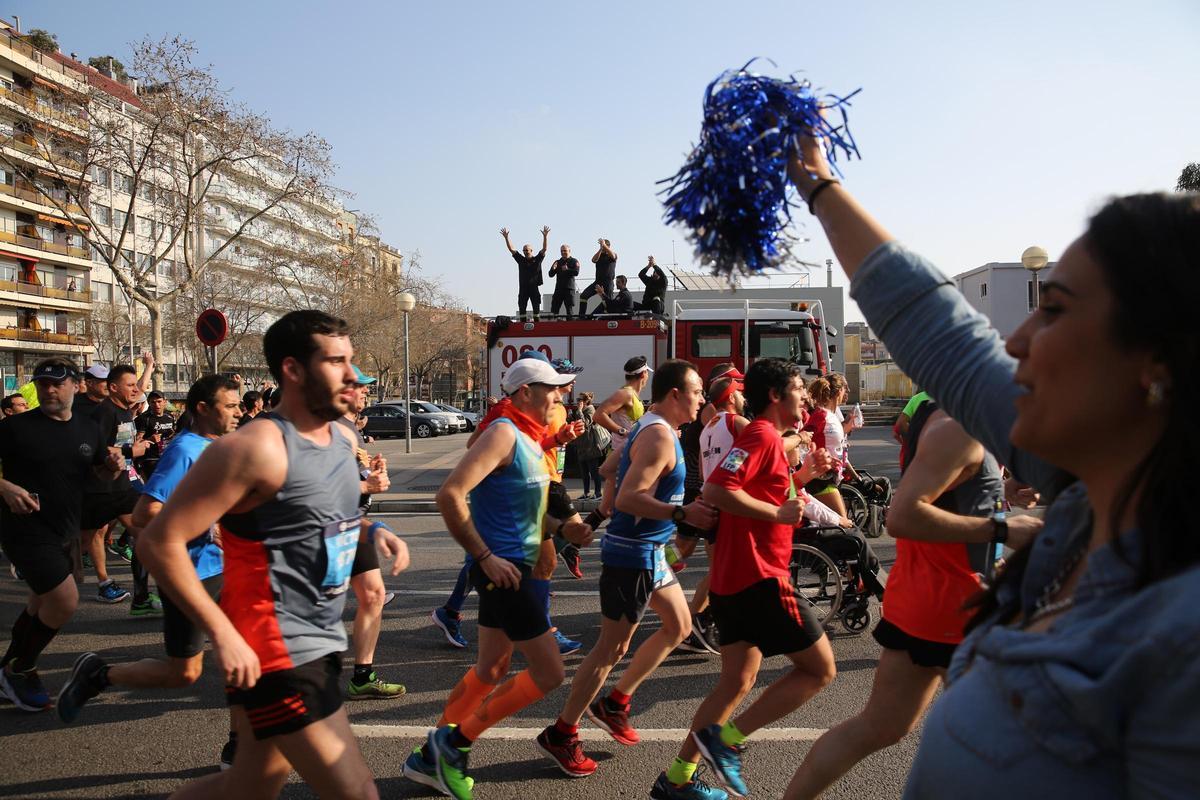 Corredores y animadores durante el transcurso de la Marató de Barcelona.